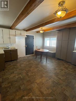 South Glengarry apartment for rent - A kitchen with wooden flooring and a person standing by the window.