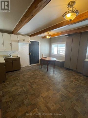 South Glengarry apartment for rent - A kitchen with wooden flooring and a person standing by the window.