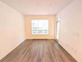 Surrey apartment for rent - A room with wooden flooring and a window showing a view of a building.
