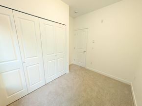 Surrey apartment for rent - A room with white doors and carpeted floor.