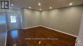 Ottawa townhouse for rent - A room with wooden flooring and a doorway leading to another room.