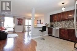 Mississauga (Central Erin Mills) townhouse for rent - A living room with a stone backsplash and wooden cabinets.