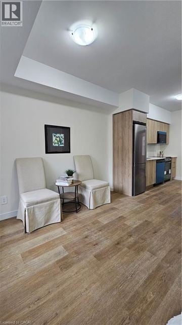 Kitchener apartment for rent - A living room with a chair and a table.