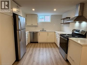 Hamilton apartment for rent - A kitchen with white cabinets and a stainless steel refrigerator.