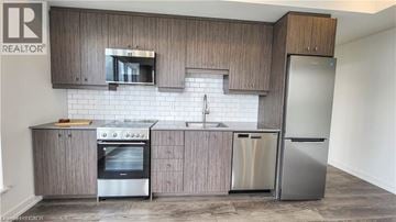 Kitchener condo for rent - A modern kitchen with wooden cabinets and stainless steel appliances.