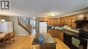 Waterloo townhouse for rent - A kitchen with wooden cabinets and a black countertop.