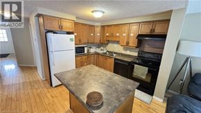 Waterloo townhouse for rent - A kitchen with wooden cabinets and a stone countertop.