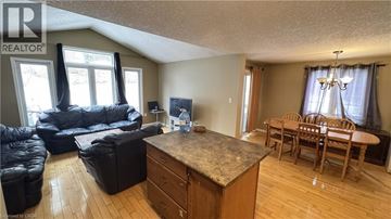 Waterloo townhouse for rent - A living room with a black leather couch and a wooden dining table.