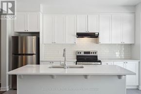Ottawa townhouse for rent - A white kitchen with a stainless steel refrigerator and a white countertop.