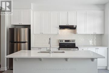 Ottawa townhouse for rent - A white kitchen with a stainless steel refrigerator and a white countertop.