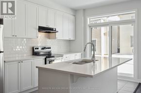 Ottawa townhouse for rent - A kitchen with white cabinets and a marble countertop.