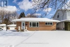 Kitchener apartment for rent - A house with a brown siding and a white roof is surrounded by snow.