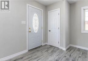 Kitchener apartment for rent - A white door with a glass window in the middle is in a room with a grey wall.