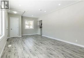 Kitchener apartment for rent - A spacious room with light grey flooring and white walls.
