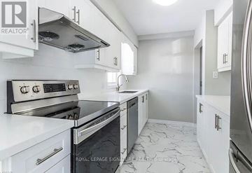 Kitchener apartment for rent - A modern kitchen with white cabinets and a black stove top oven.