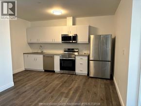 Windsor condo for rent - A kitchen with white cabinets and stainless steel appliances.