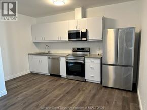 Windsor condo for rent - A kitchen with white cabinets and stainless steel appliances.