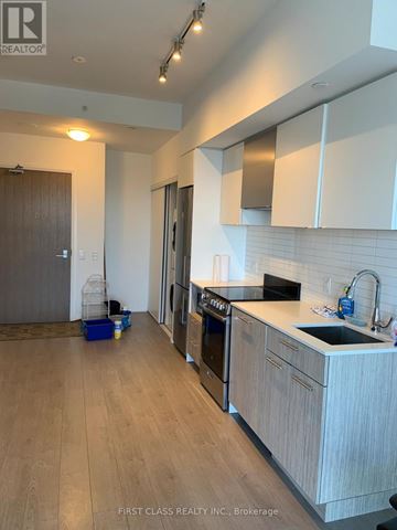 Toronto (Moss Park) condo for rent - A kitchen with a black counter top and white cabinets.