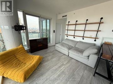 Toronto (Niagara) condo for rent - A living room with a grey couch and a yellow chair.