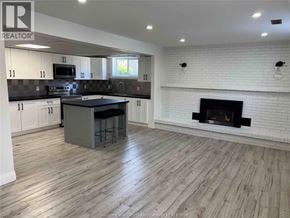 Tecumseh apartment for rent - A kitchen with a white fireplace and wooden floors.