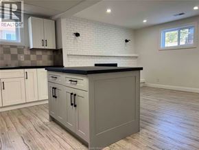 Tecumseh apartment for rent - A kitchen with a black countertop and white cabinets.
