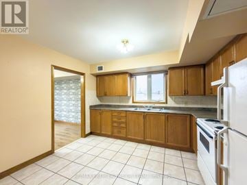 Vaughan (Maple) multi-family for rent - A kitchen with wooden cabinets and a white refrigerator.