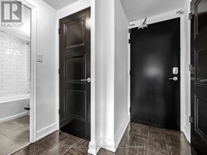 Toronto (Annex) condo for rent - A hallway with two doors and a brokerage sign on the wall.