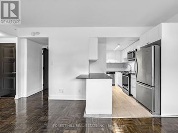 Toronto (Annex) condo for rent - A kitchen with a white fridge and stove top oven.