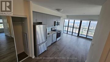 Toronto (Henry Farm) condo for rent - A kitchen with a refrigerator, cabinets, and a microwave.