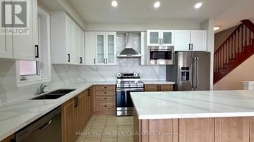 Markham (Cornell) apartment for rent - A kitchen with white cabinets and a stainless steel refrigerator.