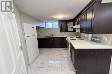 Whitby (Williamsburg) apartment for rent - A kitchen with white cabinets and a white refrigerator.