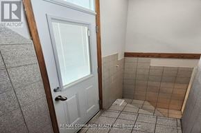 Whitby (Williamsburg) apartment for rent - A bathroom with a white door and tiled walls.