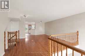 Ottawa condo for rent - A spacious room with wooden floors and a staircase.