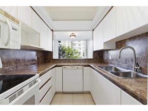 Surrey apartment for rent - A kitchen with white cabinets and a black countertop.