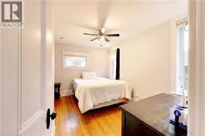 Sarnia apartment for rent - A bedroom with a bed, a ceiling fan, and a window.
