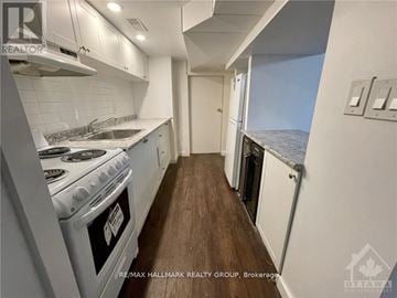 Ottawa triplex for rent - A kitchen with a stove top oven and a window overlooking the ocean.