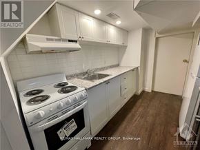 Ottawa triplex for rent - A kitchen with a stove top oven and white cabinets.