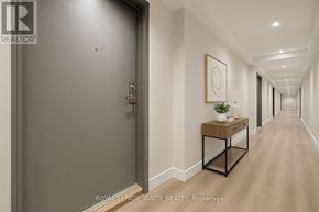 Clarington (Bowmanville) condo for rent - A hallway with a plant on a table and a framed picture on the wall.