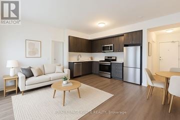 Clarington (Bowmanville) condo for rent - A modern kitchen with dark brown cabinets and stainless steel appliances.