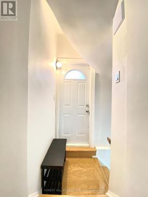 Richmond Hill (North Richvale) apartment for rent - A hallway with a white door and a bench at the bottom.