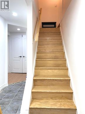 Richmond Hill (North Richvale) apartment for rent - A set of wooden stairs with a white door on the left.