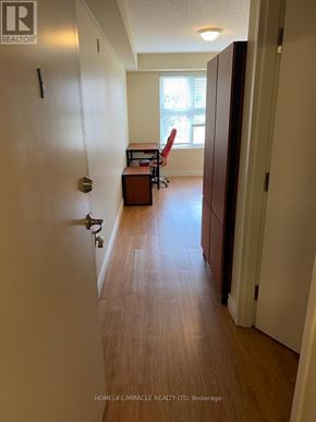 Waterloo condo for rent - A hallway with a door on the left and a desk with a chair in the background.