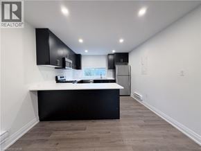 Hamilton apartment for rent - A modern kitchen with black cabinets and a white countertop.