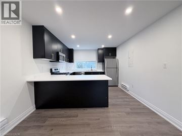 Hamilton apartment for rent - A modern kitchen with black cabinets and a white countertop.