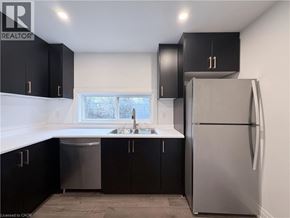 Hamilton apartment for rent - A kitchen with black cabinets and a silver refrigerator.