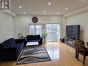 Mississauga (Churchill Meadows) townhouse for rent - A living room with a blue couch, a coffee table, and a flat screen TV.
