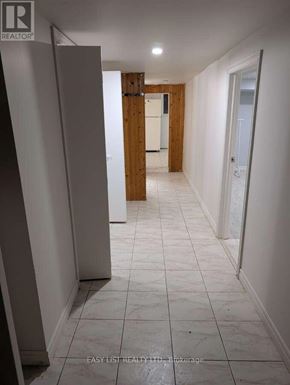 Toronto (Newtonbrook West) apartment for rent - A long hallway with white tile floors and white walls.