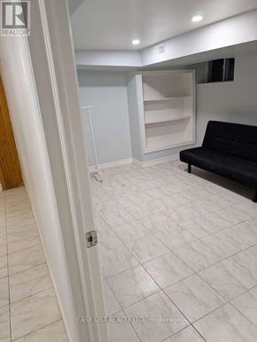 Toronto (Newtonbrook West) apartment for rent - A living room with a black couch and a white door.