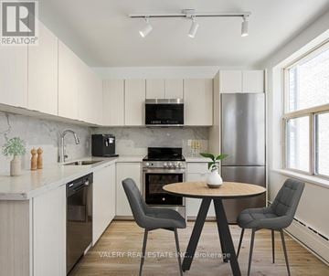 Toronto (Danforth Village-East York) condo for rent - A modern kitchen with a round table and chairs.
