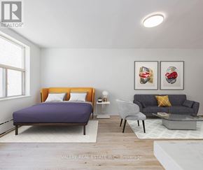 Toronto (Danforth Village-East York) condo for rent - A bedroom with a purple bed and a grey couch.